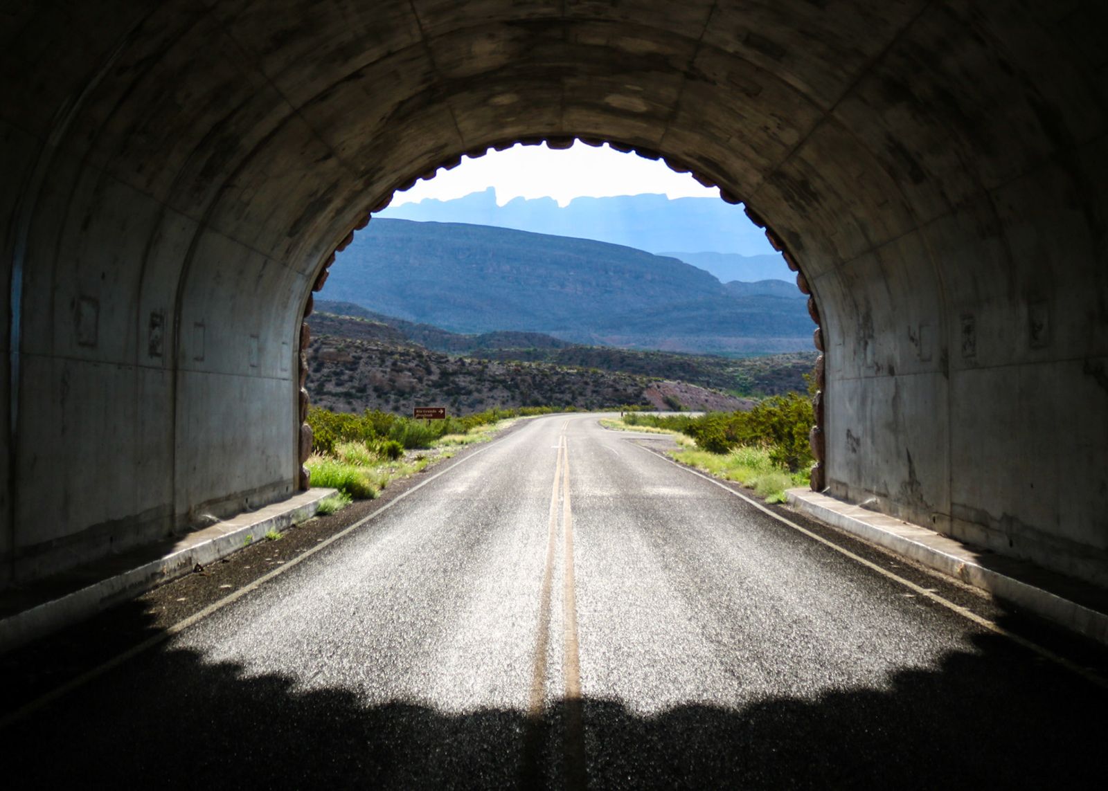 Dirt road seen through a stone tunnel opening in Big Bend National Park